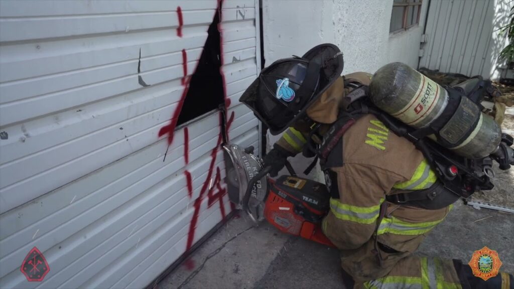 Firefighters perform forcible entry on commercial overhead sectional door