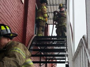 Firefighters Hoseline advance on fire escape