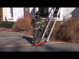 Firefighter Mike Ciampo with portable saw and ladder