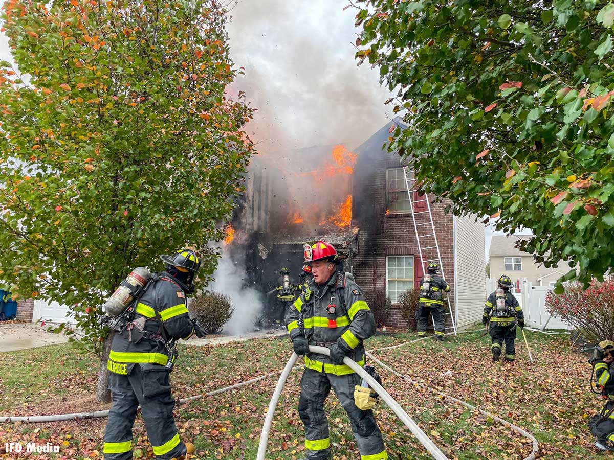 Indianapolis firefighters move hoselines at house fire