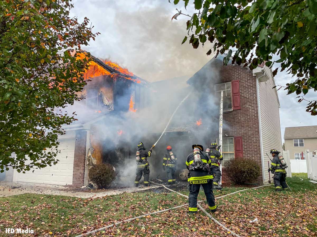 Indianapolis firefighters put water on fire from outside home