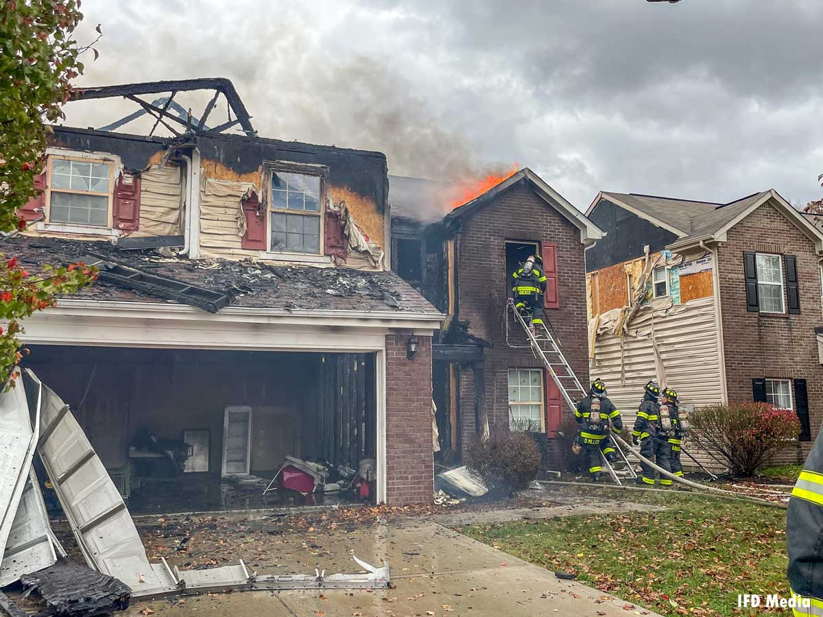 Indianapolis firefighters ascend ladder at house fire