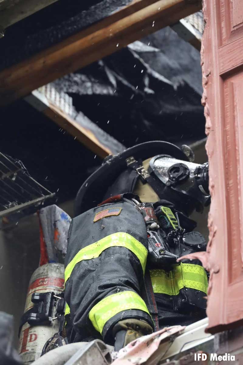 Indy firefighter in full gear doing overhaul