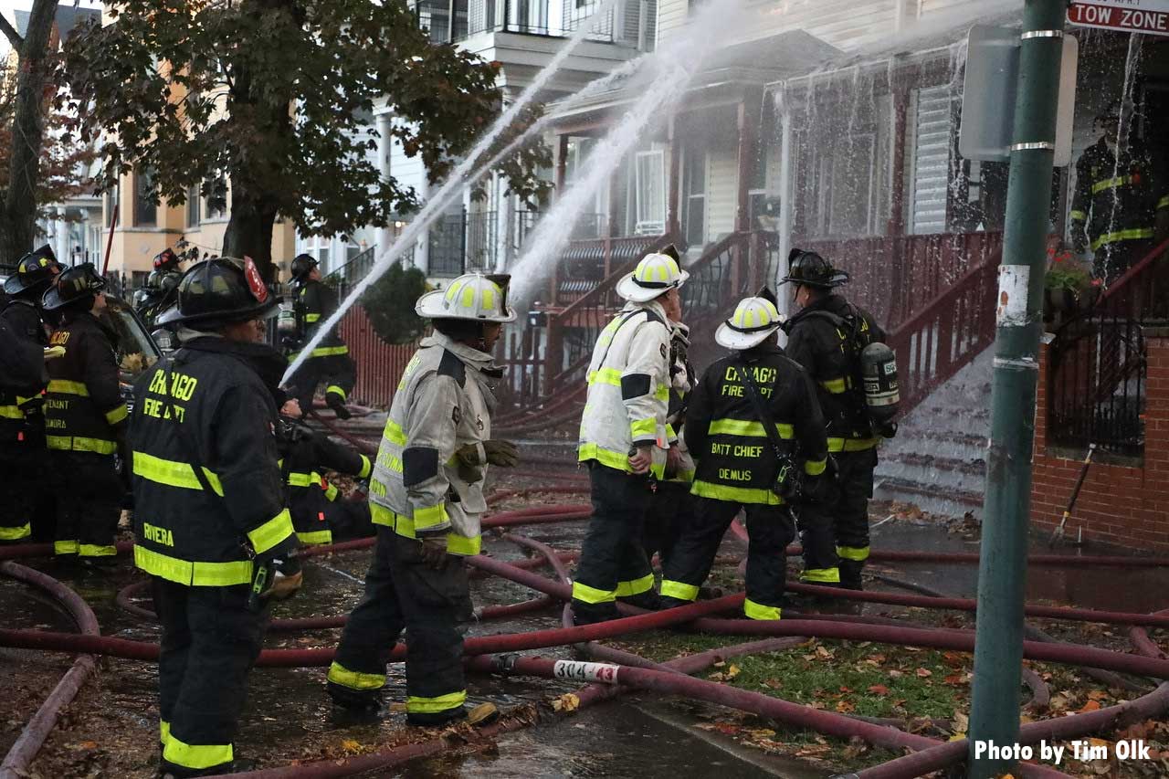 Chicago firefighters in yard with multiple water streams