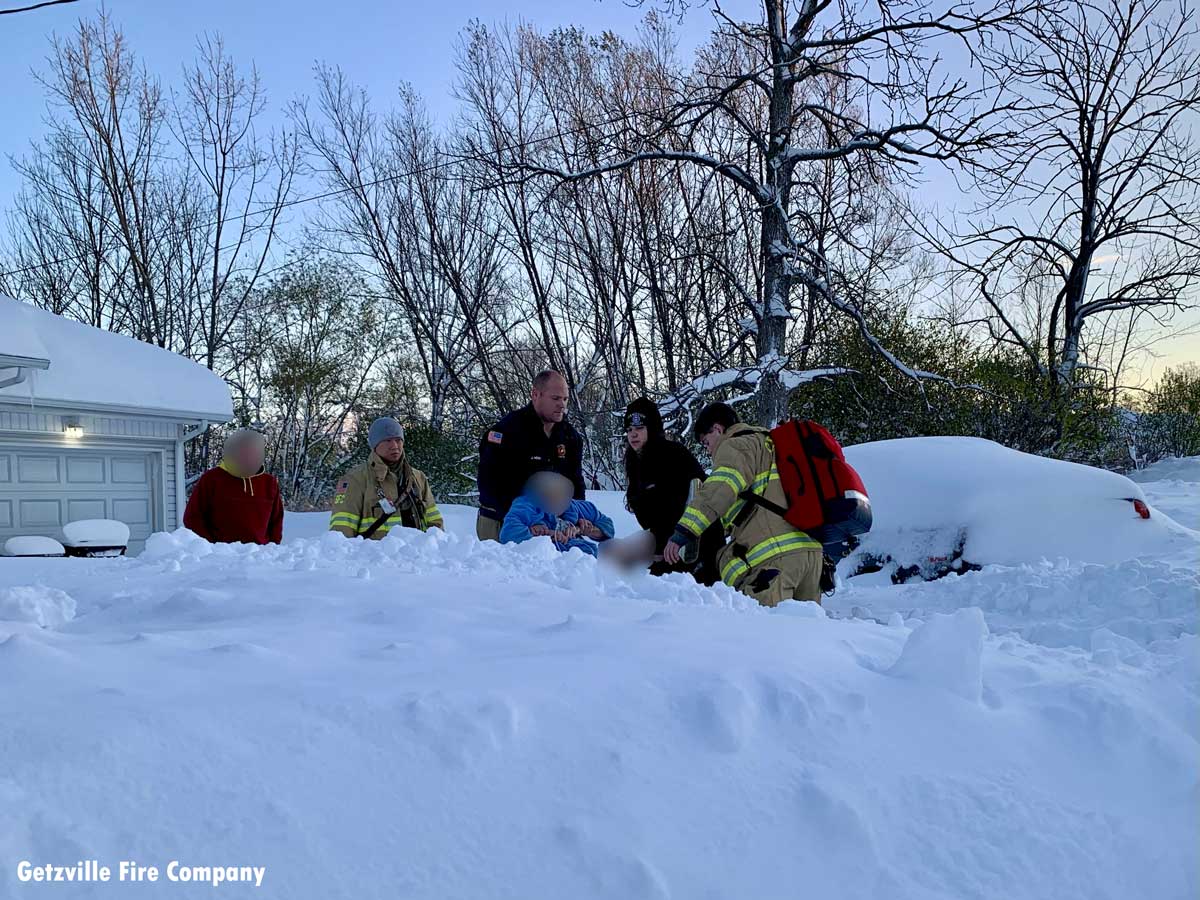 Getzville firefighters Jason Heim and Ethan Fargo carrying an Orchard Park resident through the snow to an ambulance.