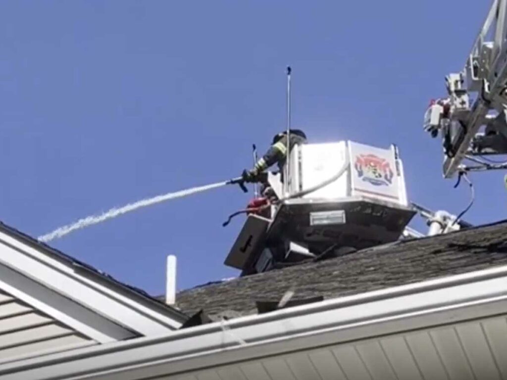 Firefighters flowing water from tower ladder bucket