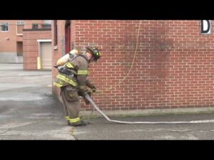 firefighter performing rope hoseline stretch