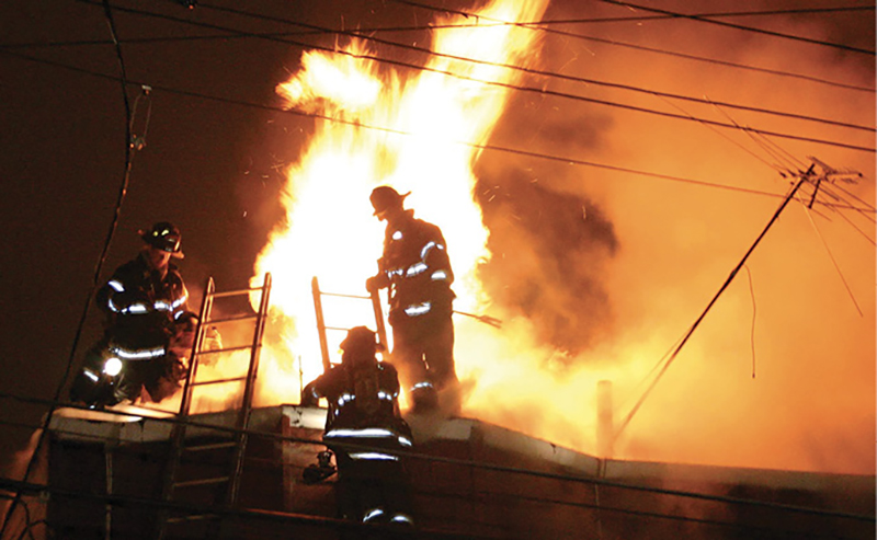 Firefighter on the roof enveloped by fire