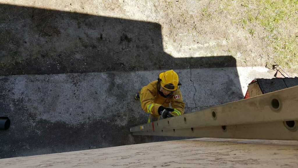 Lone firefighter placing ladder against building