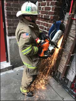 Firefighter peforms cutting operations with power saw