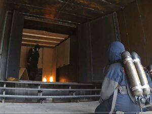 Fire instructor and student in fire demonstration chamber