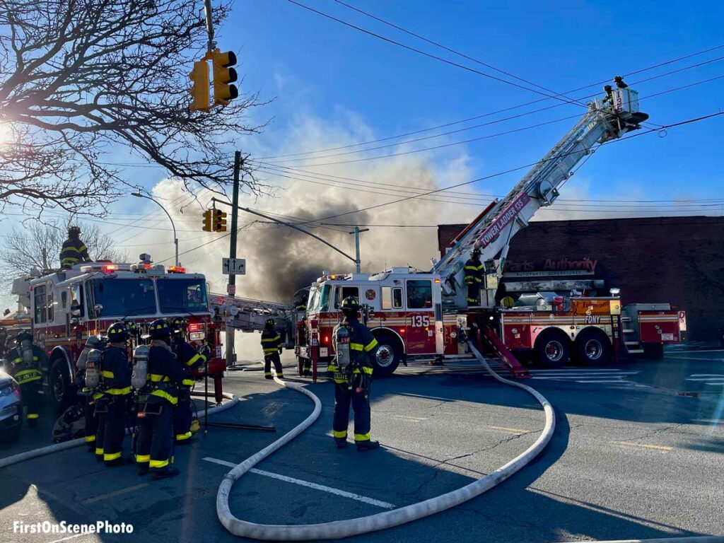 FDNY Tower Ladder and apparatus with smoke plume from Queens fire