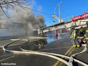 FDNY firefighters iin Tower Ladder use master stream on Queens fire