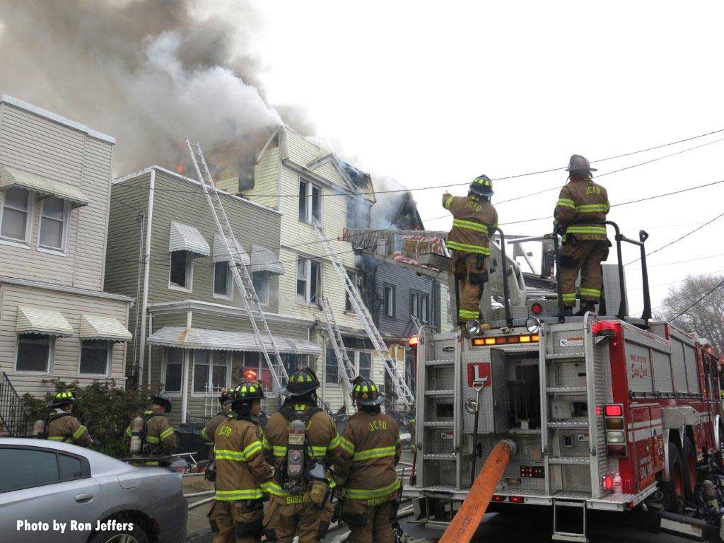 Firefighters on back of aerial apparatus at Jersey City fire