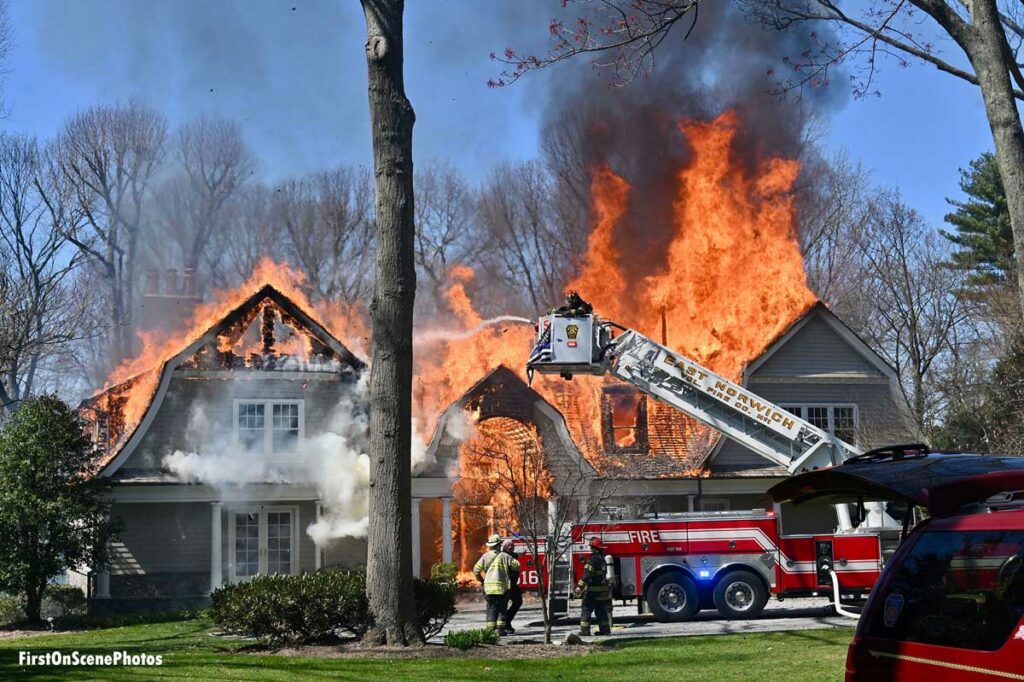 Firefighters put water on fire in large house in East Norwich New York