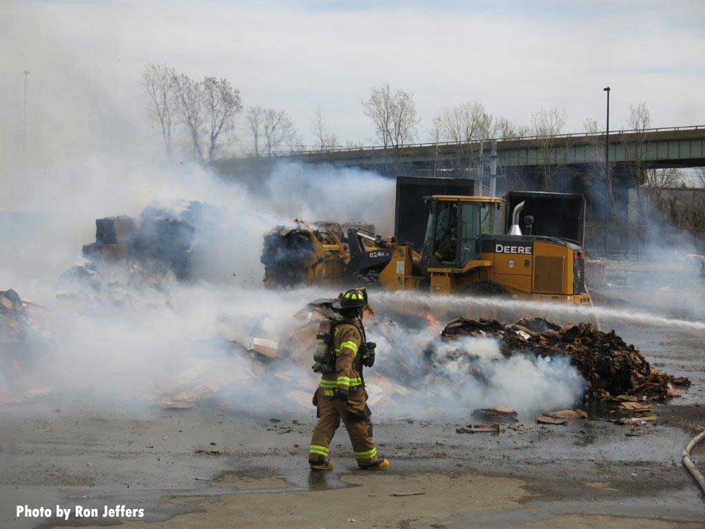 Firefighter and fire stream at recycling plant fire in Jersey City