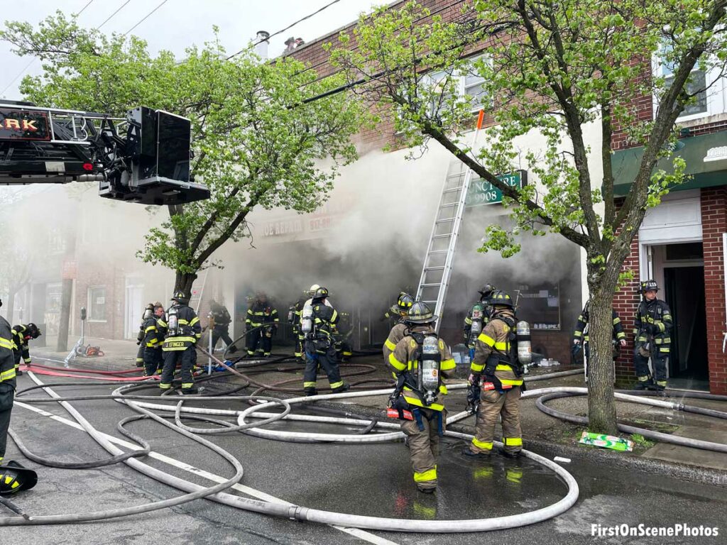 Firefighters, hoselines, and tower ladder bucket at Floral Park fire