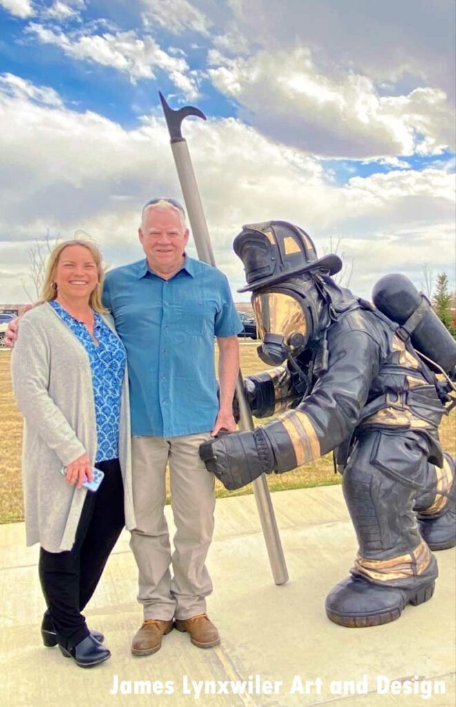 Scultpor and woman with firefighter statue