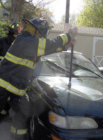 Firefighter spiking the hood with a halligan