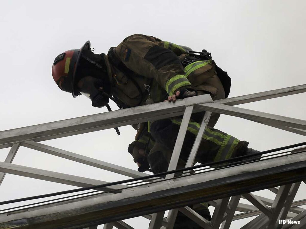 Firefighter descending an aerial ladder