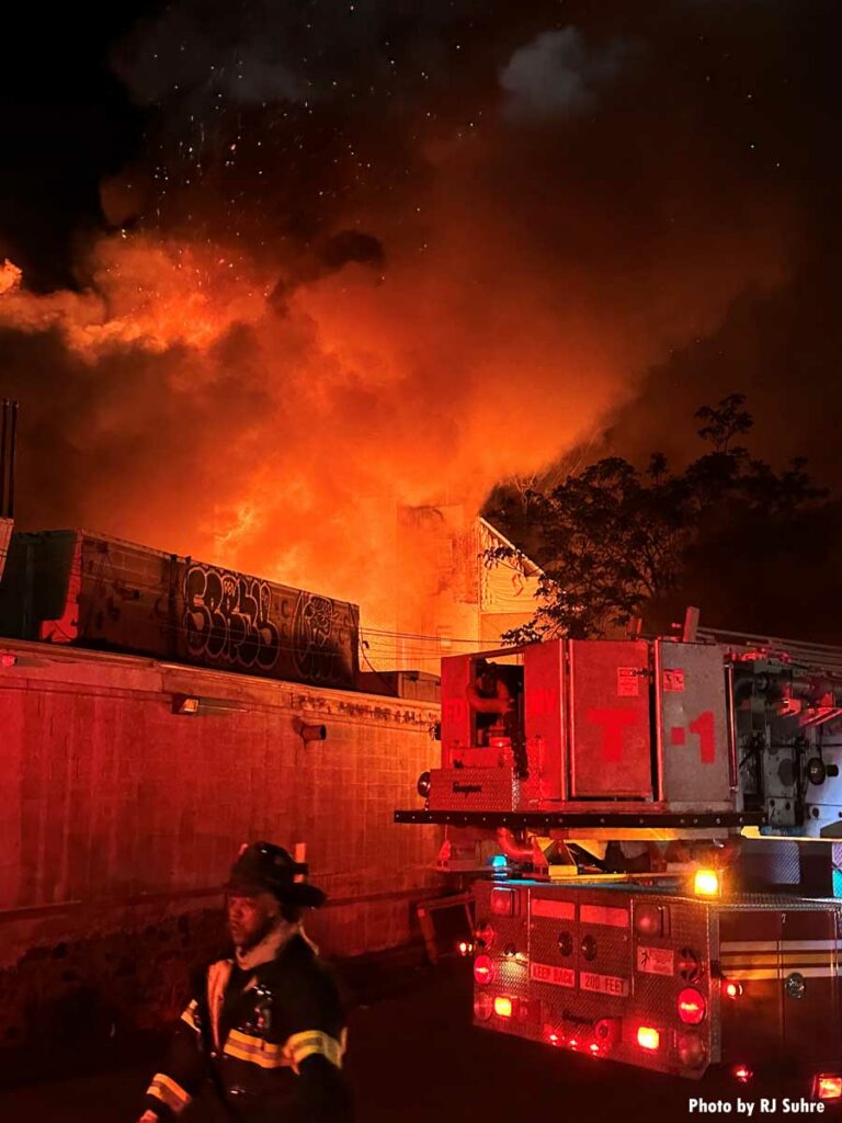 Flames shoot up to the sky with firefighter in foreground