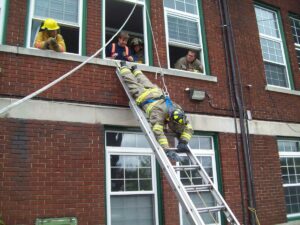 Firefighter performs a headfirst window bailout during training