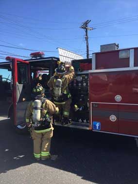 Firefighters pull hoseline from hosebed