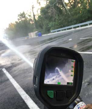 Firefighter uses thermal imager TIC on water stream