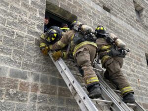 Firefighters training on ground ladder rescue