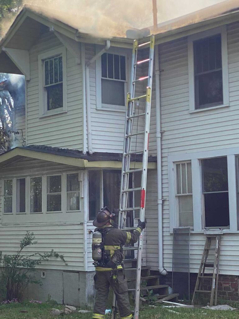 Firefighter holding a ground ladder