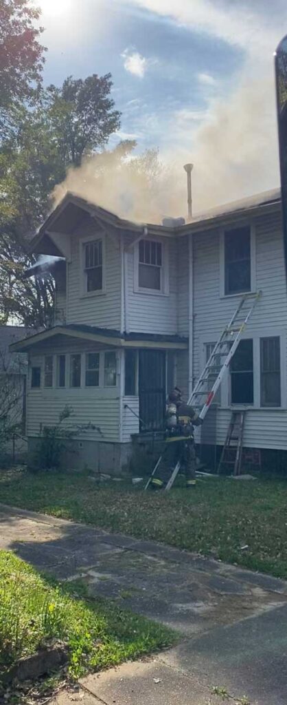 Firefighter sets up ladder at fire scene