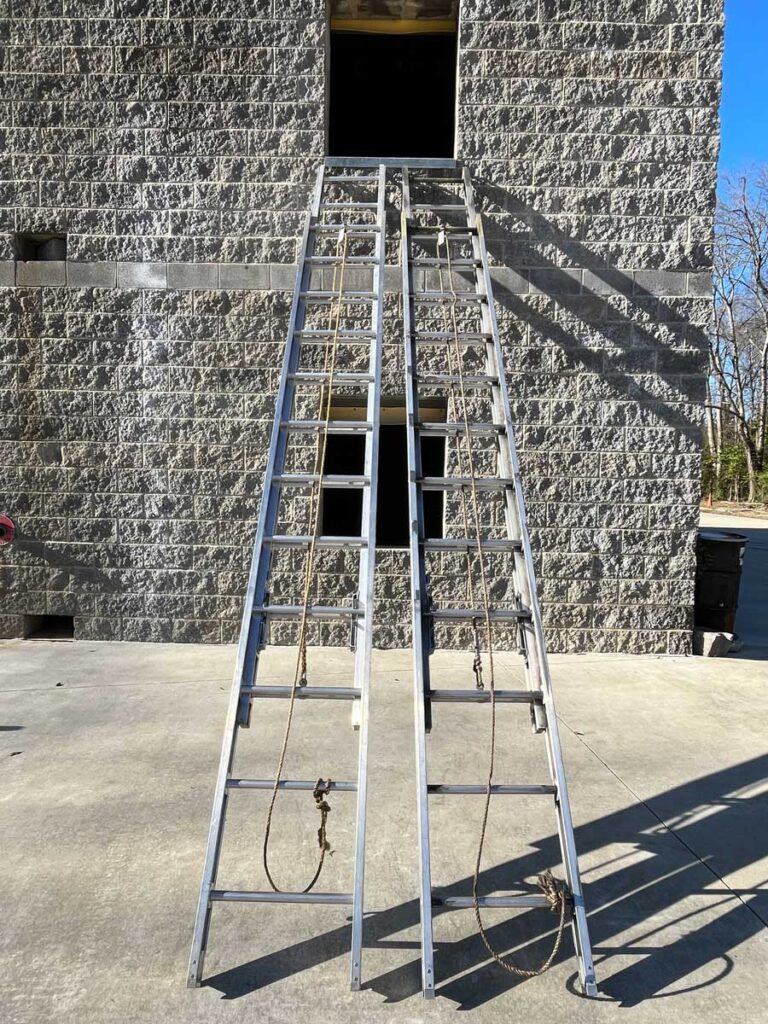 Ground ladders side by side set at window