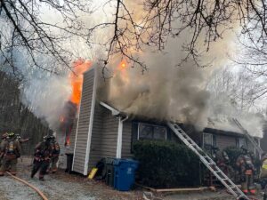 Firefighters with ladders at house fire