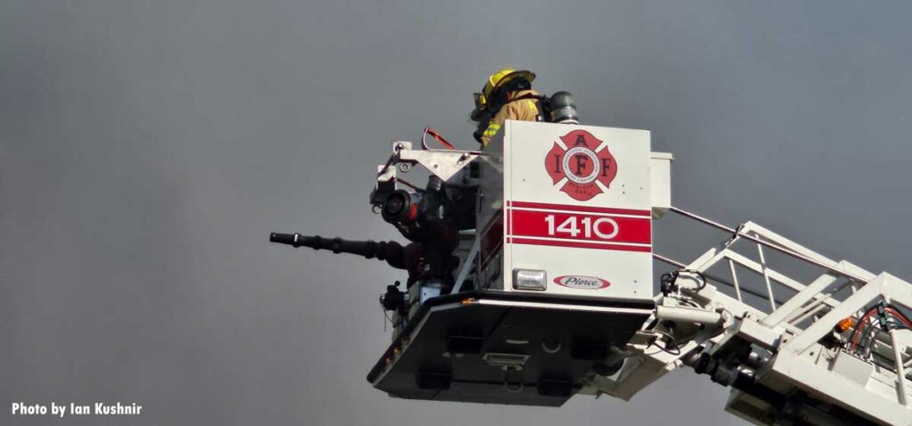 IAFF 1410 logo and firefighters in tower ladder bucket