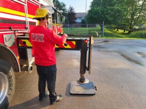 Firefighter uses hook to measure outrigger space