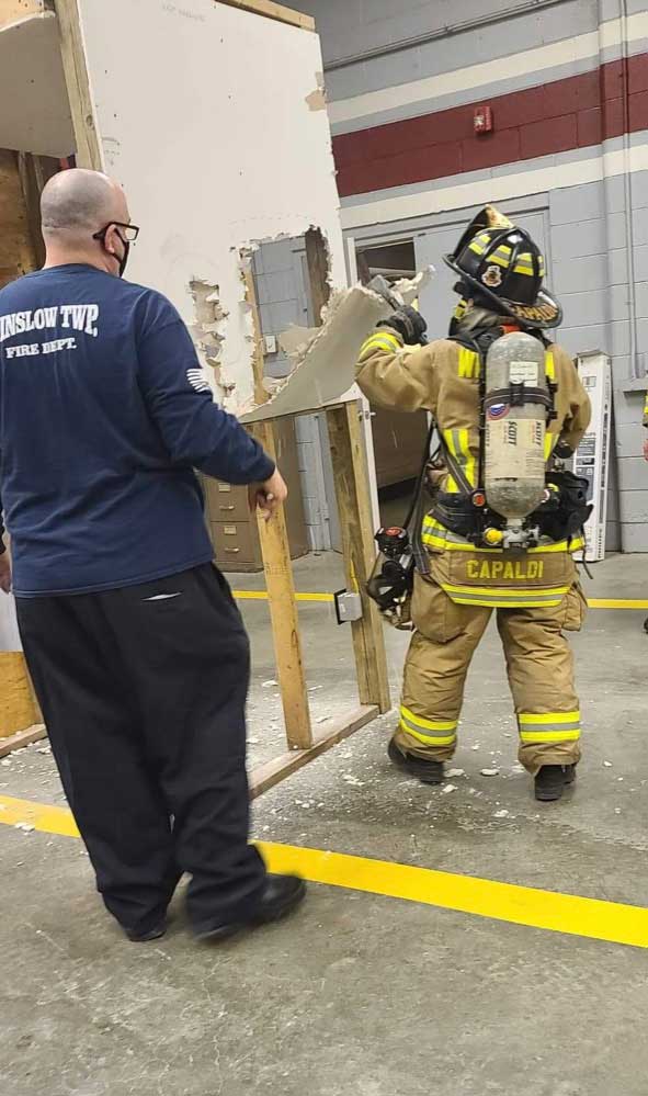 Firefighter trains punch technique on training prop sheetrock