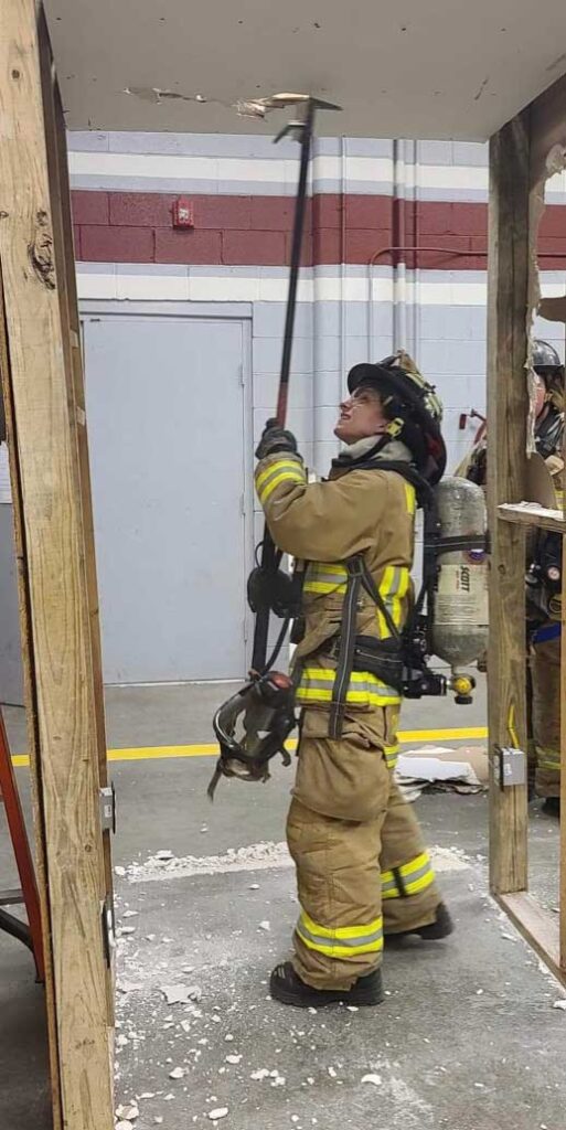 Firefighter pulls ceiling in hallway training prop