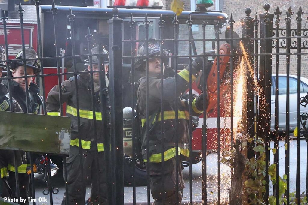 Chicago firefighters use saw to cut fence