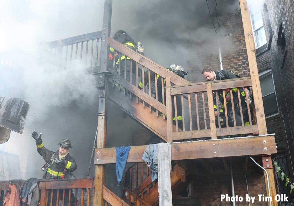 Chicago firefighters advance up stairs on rear of home