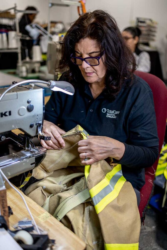 Woman sewing firefighter turnout gear