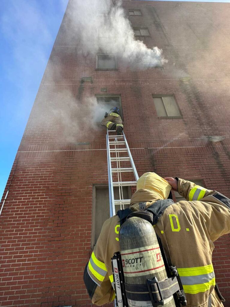 Firefighters ascending ladder