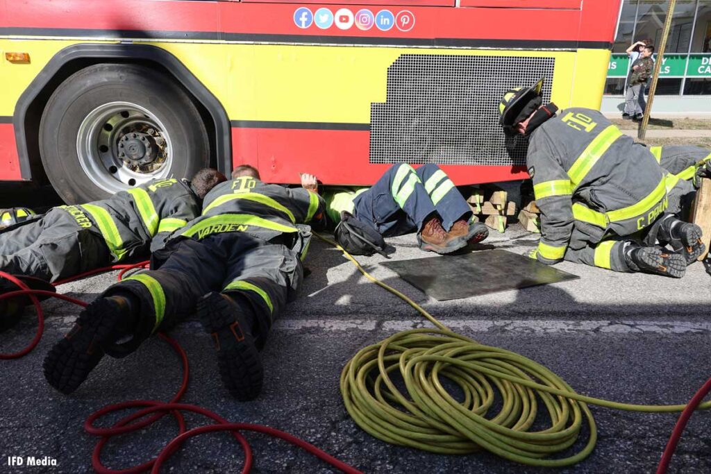 Indianapolis firefighters work to free victim pinned under bus