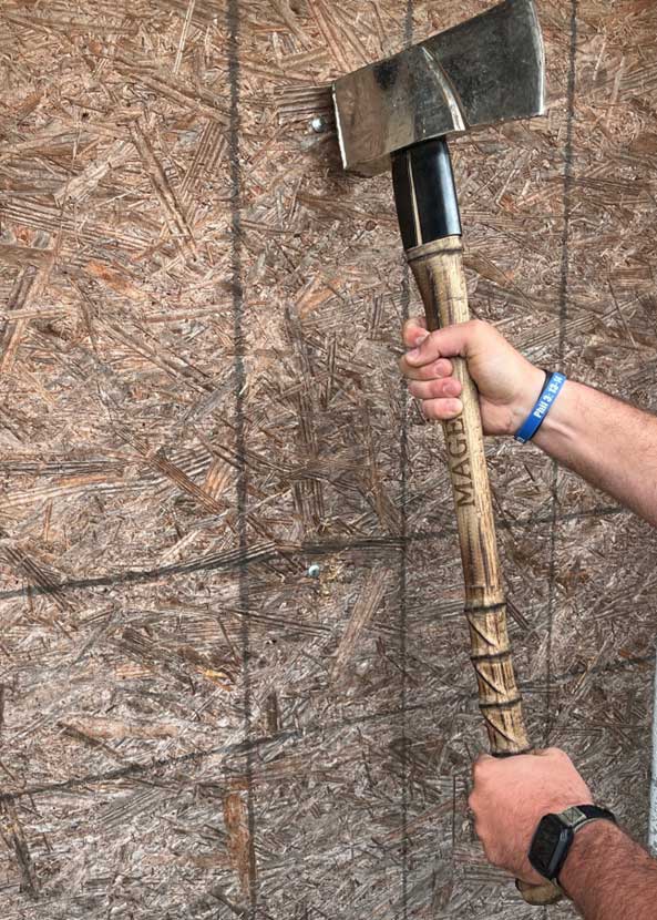 Hands holding an ax outside board