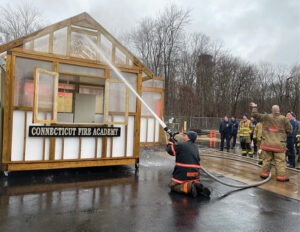 Firefighters extinguish fire with outside stream in training bootcamp