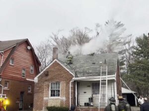 Firefighters on roof performing vertical ventilation