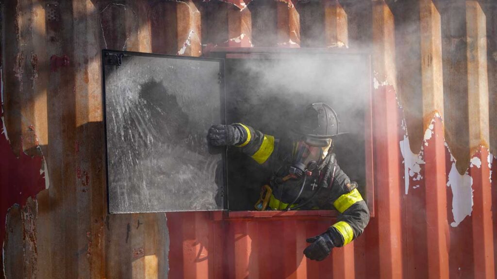 Firefighter opens a door on burn building