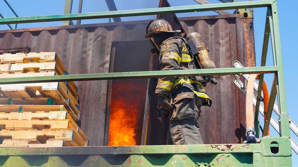 Firefighter opens a door to flames