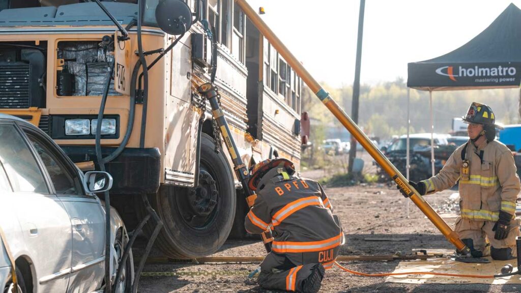 Firefighters using struts on school bus