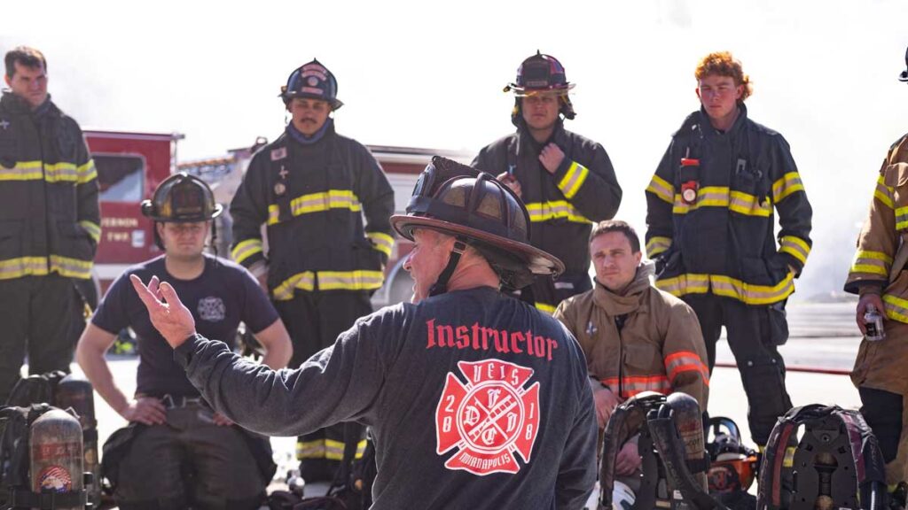 Fire instructor with firefighters at FDIC 2024