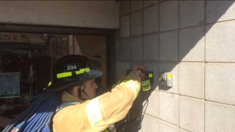 Firefighter looks at wall panel